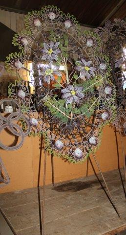 An oval beaded floral display on tripod stand